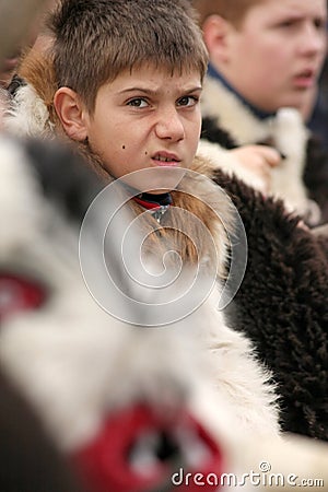 Kids mummers with heavy masks on a international festival of masquerade games â€œSurvaâ€. Kukeri. Editorial Stock Photo